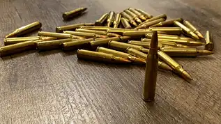 Ammo storage boxes with loose rounds on a table.